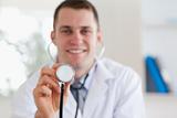 Smiling doctor using stethoscope