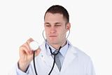 Close up of doctor looking at his stethoscope while using it