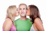 two young women kissing  handsome man standing between them - isolated on white