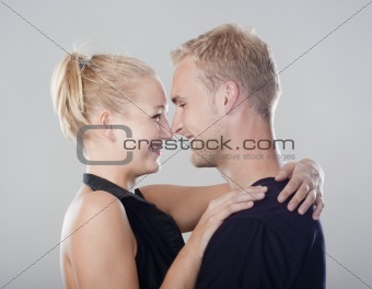 young happy couple embracing, smiling - isolated on light gray