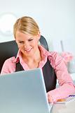 Smiling business woman working on laptop at office
