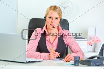 Smiling modern female manager with headset at working place
