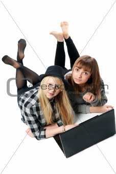 Two girls lies with computer