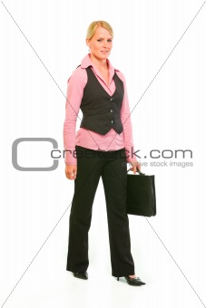 Happy modern business woman with suitcase making step
