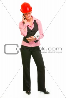 Full length portrait of modern architect woman with flipcharts talking mobile

