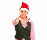 Smiling modern business woman in Santa Hat showing thumbs up

