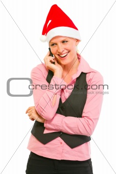 Smiling modern business woman in Santa Hat talking cell phone
