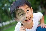 asian boy holding magnifier