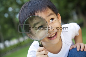 asian boy holding magnifier