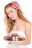 Woman with pink flower and spa products