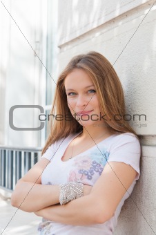 young woman standing by white wall 