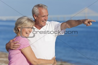 Happy Senior Couple Walking Pointing on Beach
