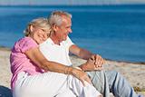 Happy Romantic Senior Couple Sitting Together on Beach