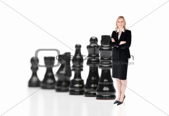 Businesswoman in front of black chess pieces