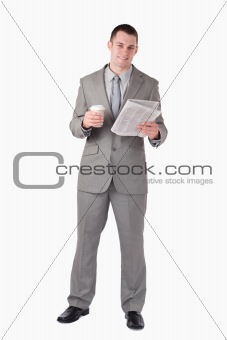 Portrait of a businessman reading the news while holding a cup of tea