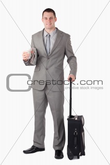 Portrait of a businessman holding a cup of coffee and a suitcase