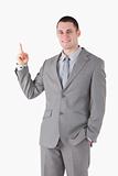 Portrait of a smiling young businessman pointing at something