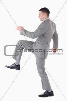 Portrait of a businessman lifting his leg up
