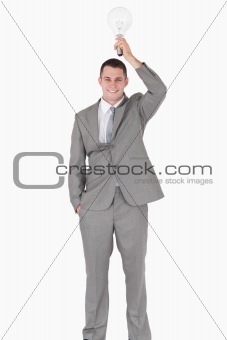 Portrait of a businessman holding a bulb above his head