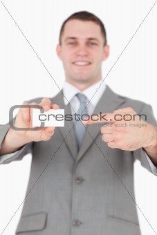 Portrait of a young businessman pointing at a blank business card
