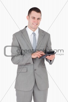 Portrait of a smiling businessman working with a calculator