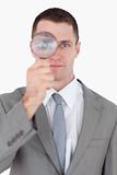 Portrait of a businessman looking through a magnifying glass