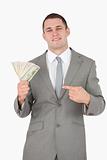 Portrait of a businessman pointing at a wad of cash