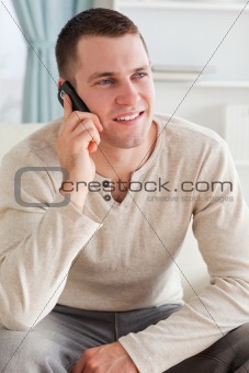 Portrait of a man making a phone call while sitting on a sofa