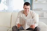 Happy man reading a newspaper