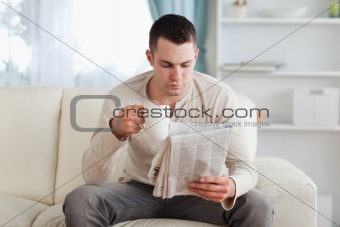Man reading the news while drinking a coffee