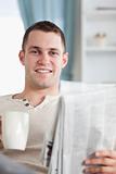 Portrait of a handsome man having a coffee while reading the news