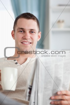 Portrait of a handsome man having a coffee while reading the news