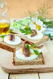 snacks sandwiches with egg and anchovies on a wooden board