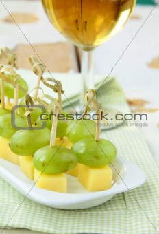 appetizer canape cheese with white grapes on bamboo skewers