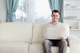 Man using a laptop while sitting on a sofa