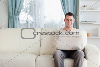 Man using a laptop while sitting on a sofa