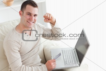 Young man shopping online with the fist up