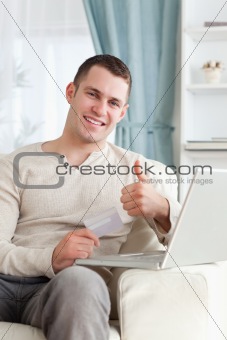 Portrait of a man shopping online with the thumb up
