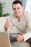 Portrait of a man purchasing online with the thumb up