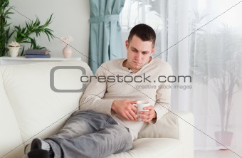 Sad man holding a cup of coffee