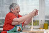 Elderly woman kneading dough