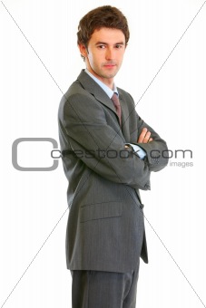 Confident modern businessman with crossed arms standing profile
