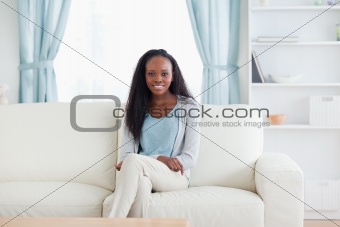 Smiling woman sitting on sofa