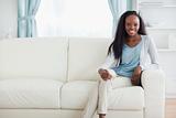 Woman sitting on sofa with legs crossed