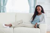 Woman sitting with legs on her sofa