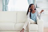 Woman talking on the phone while sitting on the sofa