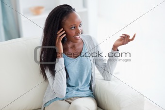 Woman talking on the phone while sitting in the living room