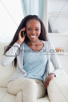 Close up of woman with her mobile phone on the sofa
