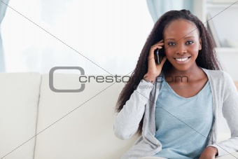 Young woman with cellphone on the sofa