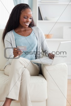 Woman sitting on sofa shopping online